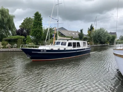 motorjacht op een kanaal met bomen op wal