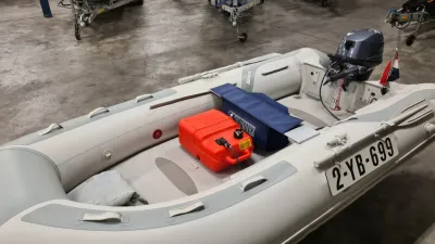 Rubberboot met buitenboordmotor in opslagruimte