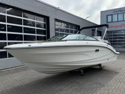 witte bowrider op parkeerplaats bij showroom