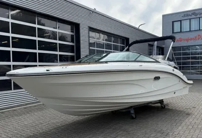 witte sportboot op trailer bij bedrijfspand