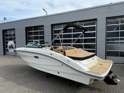 Witte sportboot geparkeerd voor bedrijfsgebouw