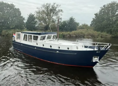 blauwe motorcruiser op rivier bij oever