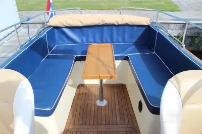 kuip met blauwe kussens en houten tafel