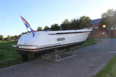 witte sloep op bok met Nederlandse vlag
