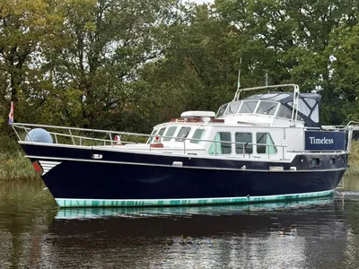 kotter op rustig water met bomen op achtergrond