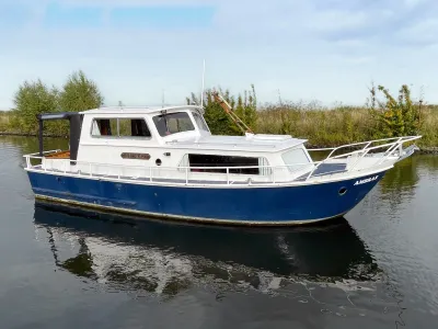 wit-blauw motorjacht op water
