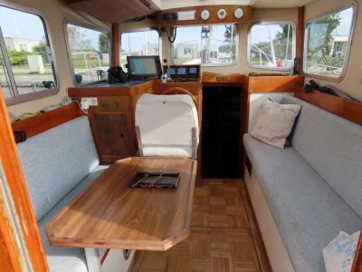 interieur van boot met stuur en zithoek