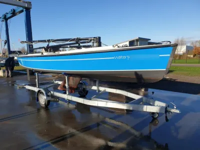 blauwe zeilboot op trailer buiten