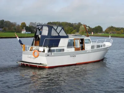 motorjacht op water met groene oever op achtergrond