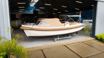 sloep in loods met afdekzeil en vlag