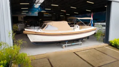 sloep binnen in loods op bok