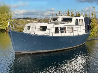 witte en blauwe motorboot op water bij wal