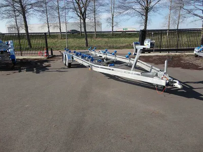 boottrailer op asfalt met hek op achtergrond