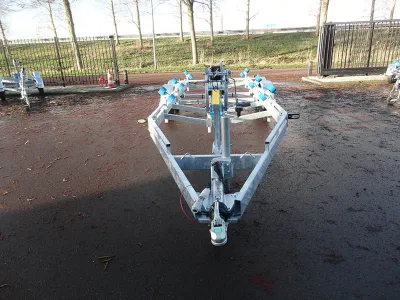 boottrailer op asfalt met hek op achtergrond