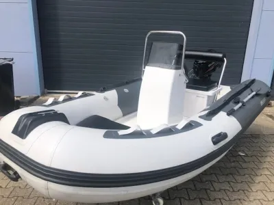 grijs-witte rib rubberboot geparkeerd voor loods