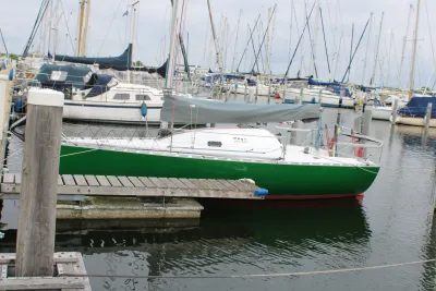 groene zeilboot aan steiger in jachthaven