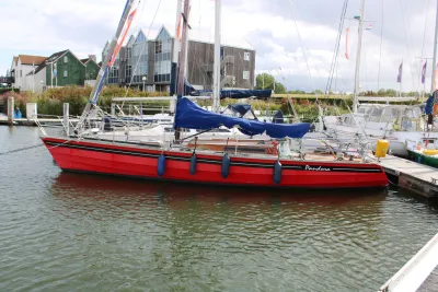 rode zeilboot aangemeerd in jachthaven