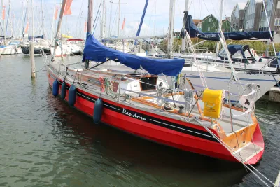 Rode zeilboot afgemeerd in jachthaven