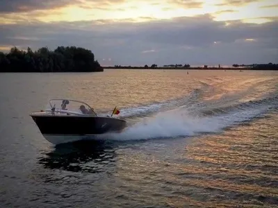 motorboot rijdend op water bij zonsondergang