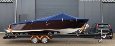 houten motorboot op trailer bij industrieel gebouw