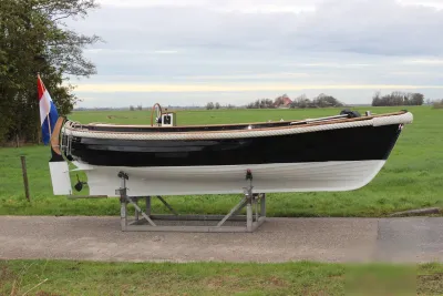 sloep op bok bij grasveld