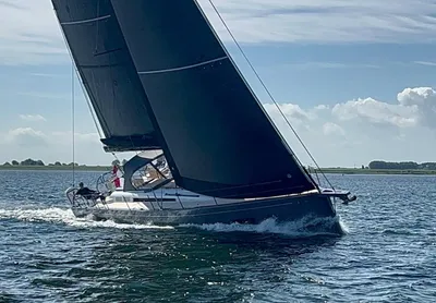 zeiljacht op open water naast kustlijn
