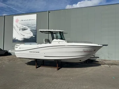 wit motorjacht buiten voor loods
