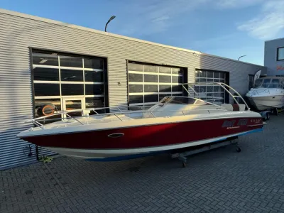 Rood-witte boot op trailer bij bedrijfspand