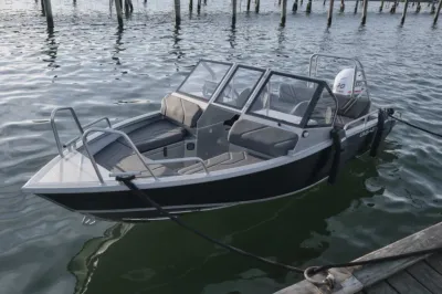 Aluminium sportboot afgemeerd bij steiger