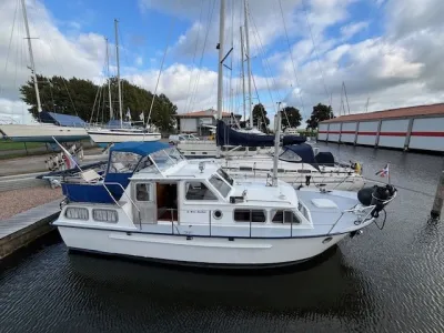 Wit motorkruiser aangemeerd in jachthaven