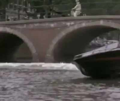 snelboot op kanaal bij stenen brug