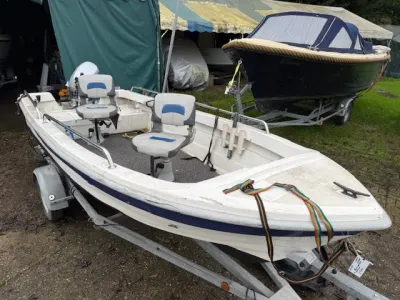 wit visboot op trailer in opslag