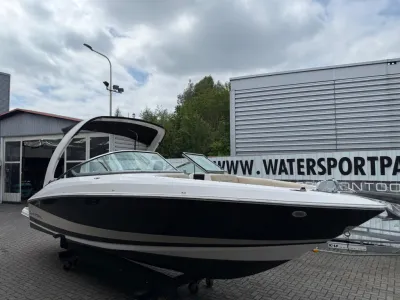 wit-zwarte sportboot op trailer bij bedrijf