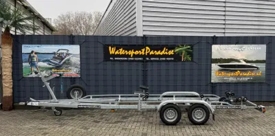boottrailer geparkeerd voor hek met borden
