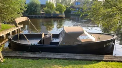 zwarte cabinboot aangemeerd bij kade