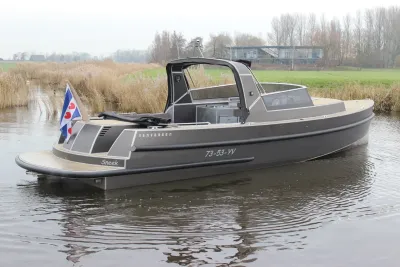 grijze cabincruiser op stil water met riet