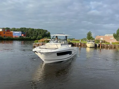 wit motorjacht in kanaal bij aanlegsteiger