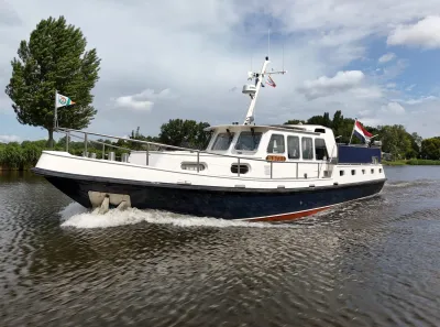 motorjacht varend op kanaal bij bewolkte hemel