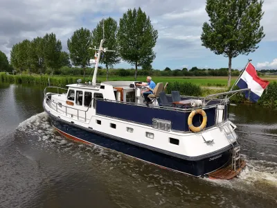 motorjacht varend op kanaal met bomen
