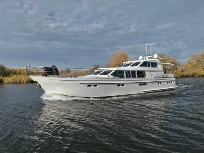 wit motorjacht op rivier bij bewolkte lucht