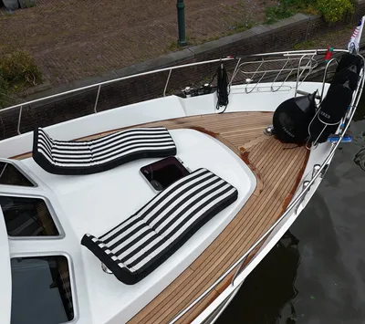 boeg van een jacht met teakdek en ligbedden