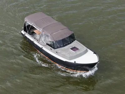 kleine kajuitboot met kap op het water