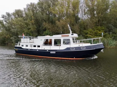 wit-blauw motorjacht op kanaal