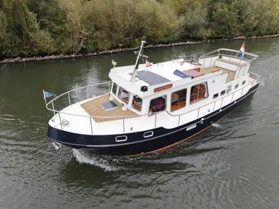motorjacht op rivier langs beboste oever