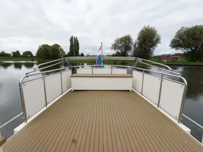 achterdek van motorjacht met reling en vlag