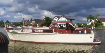 houten motorjacht aangemeerd aan kanaal