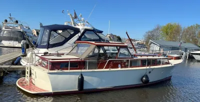 houten motorjacht afgemeerd in jachthaven