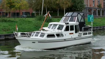 wit motorjacht op kanaal bij kade