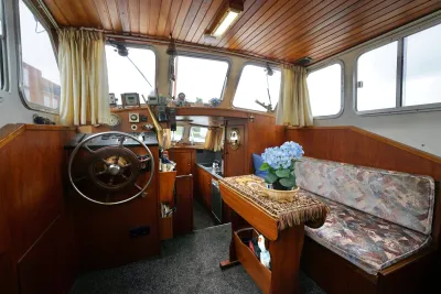 interieur van motorjacht met stuur en zithoek