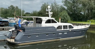 wit-grijs motorjacht aangemeerd in jachthaven